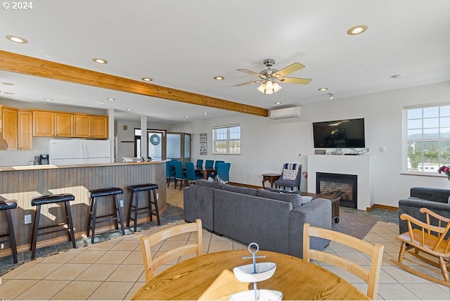 tiled dining room featuring ceiling fan, plenty of natural light, beam ceiling, and a wall unit AC