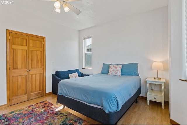 bedroom featuring light wood-style flooring, baseboards, and a ceiling fan