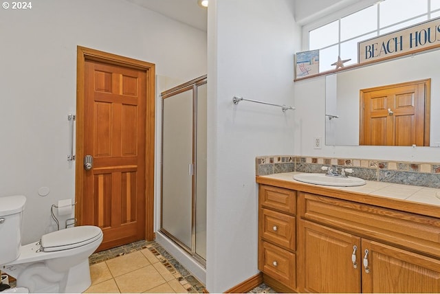 bathroom featuring a shower with door, tile patterned floors, vanity, and toilet