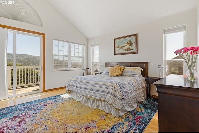 bedroom featuring access to outside, light wood-type flooring, and lofted ceiling