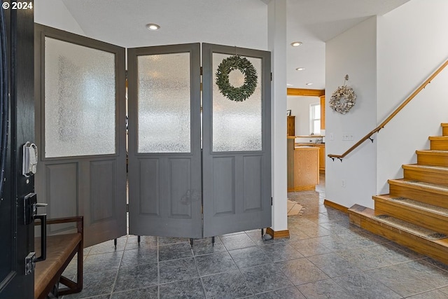 entryway featuring baseboards, stairway, and recessed lighting