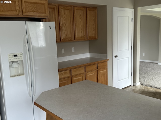 kitchen featuring white fridge with ice dispenser and light carpet