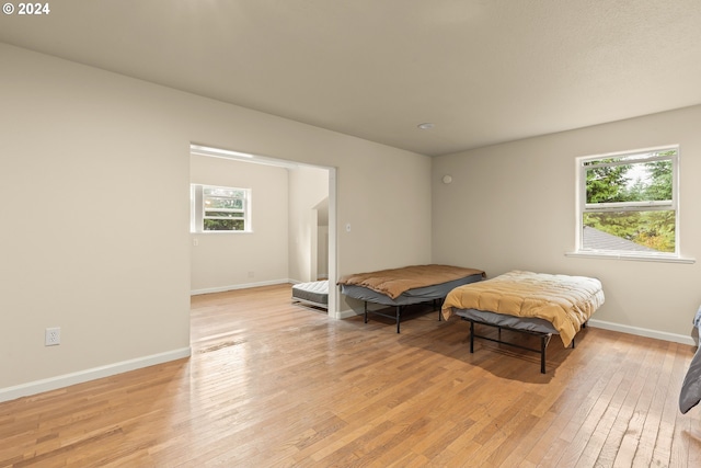 bedroom featuring light wood-type flooring and multiple windows