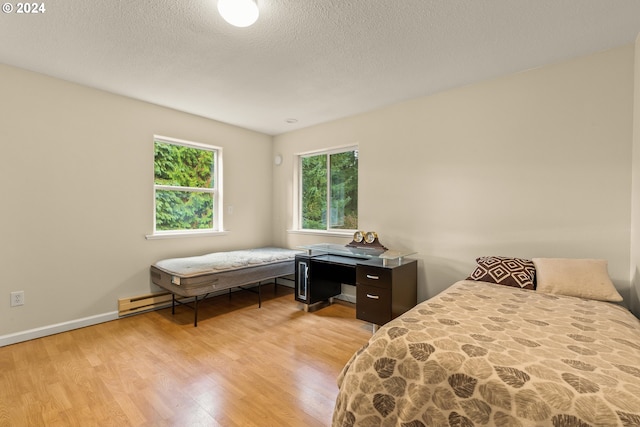 bedroom featuring a textured ceiling and light wood-type flooring