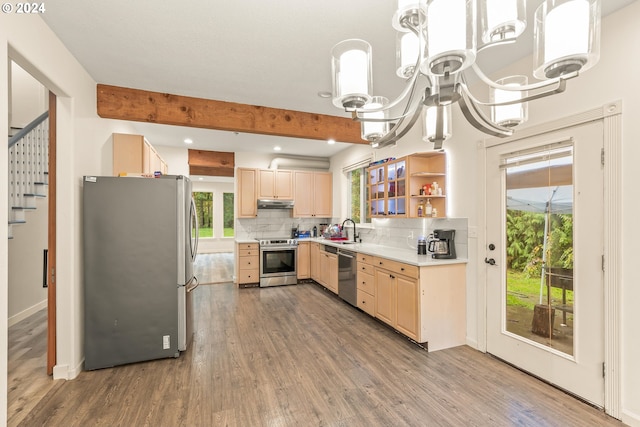 kitchen with beam ceiling, appliances with stainless steel finishes, sink, and wood-type flooring