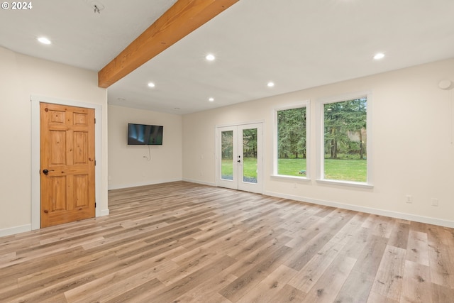 unfurnished living room featuring light wood-type flooring, french doors, and beam ceiling