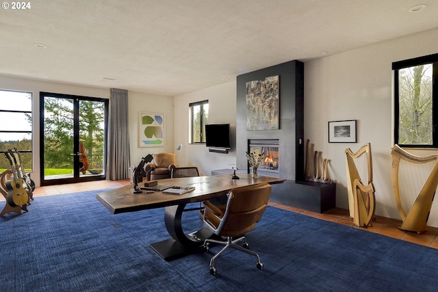 office with a multi sided fireplace and light tile patterned flooring