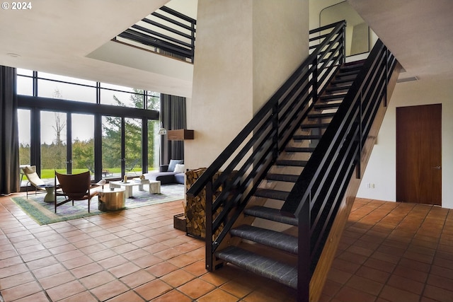 stairs with tile patterned flooring and floor to ceiling windows