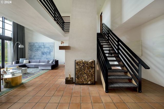 stairway featuring tile patterned flooring and a towering ceiling