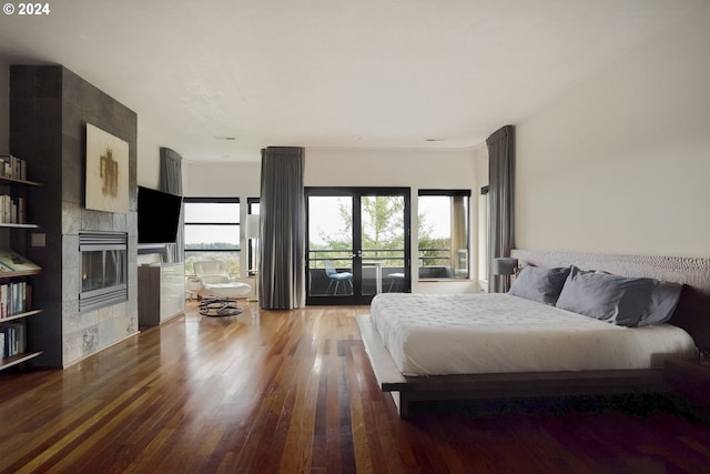 bedroom featuring a fireplace, hardwood / wood-style floors, french doors, and access to exterior