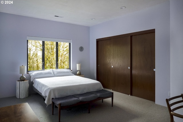 bedroom featuring light carpet and a closet