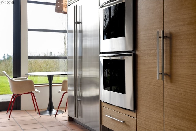 kitchen with plenty of natural light, light tile patterned flooring, and appliances with stainless steel finishes