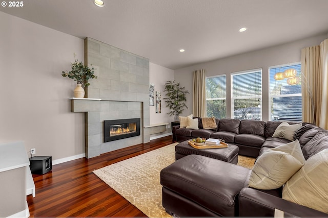 living room with recessed lighting, baseboards, dark wood finished floors, and a tile fireplace