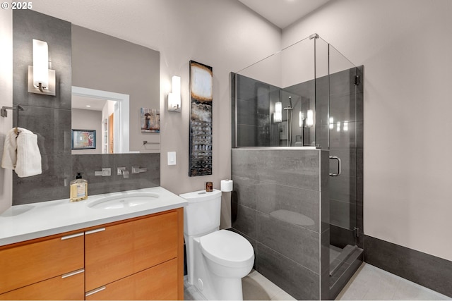 bathroom featuring decorative backsplash, a stall shower, vanity, and toilet