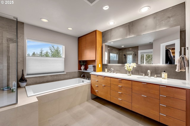 full bathroom featuring tile patterned flooring, a sink, a shower stall, and double vanity