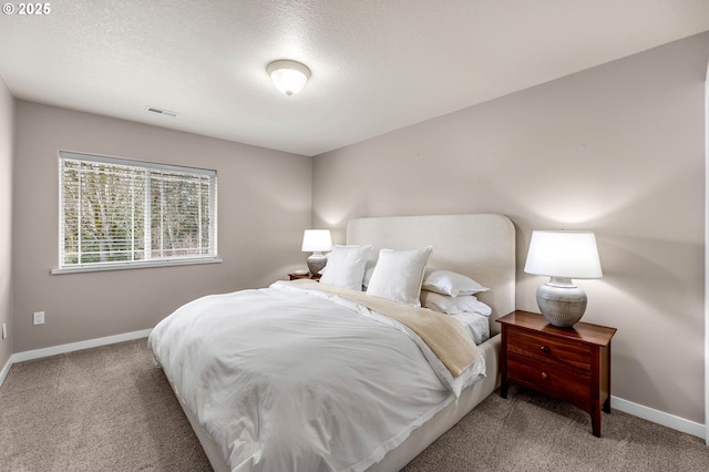 carpeted bedroom featuring visible vents, baseboards, and a textured ceiling