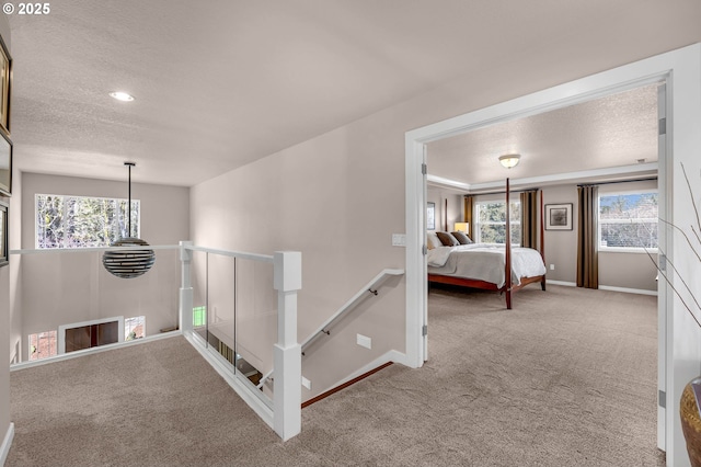 interior space with carpet flooring, a textured ceiling, and baseboards