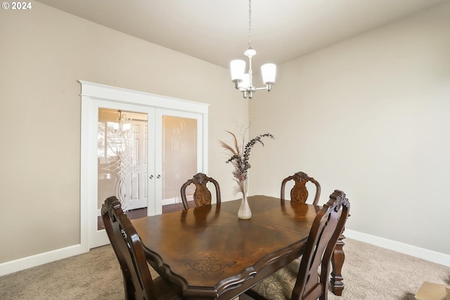 dining area featuring french doors, light colored carpet, and a chandelier