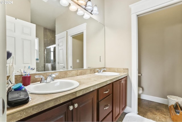 bathroom featuring vanity, a shower with door, and toilet