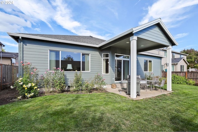 rear view of property with a yard and a patio area