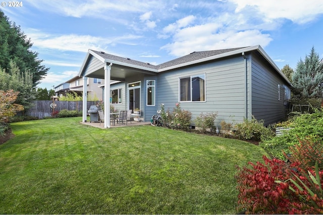 rear view of property featuring a patio and a yard