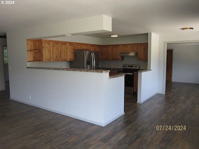 kitchen with dark hardwood / wood-style floors, dark stone counters, stainless steel fridge, and electric range