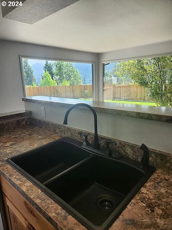 591 Fairchild St, Canyonville, OR 97417 - kitchen view of a sink, dark countertops, and a textured ceiling