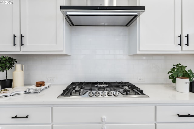 kitchen featuring stainless steel gas cooktop, white cabinetry, extractor fan, and tasteful backsplash