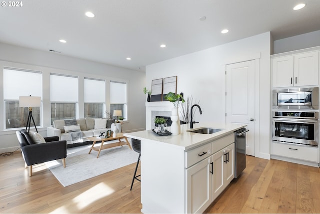 kitchen with white cabinetry, sink, an island with sink, and stainless steel appliances