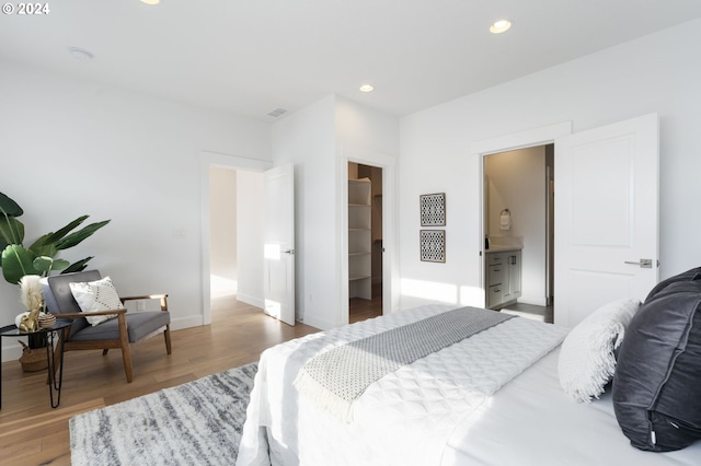 bedroom featuring a closet, a spacious closet, hardwood / wood-style floors, and ensuite bathroom