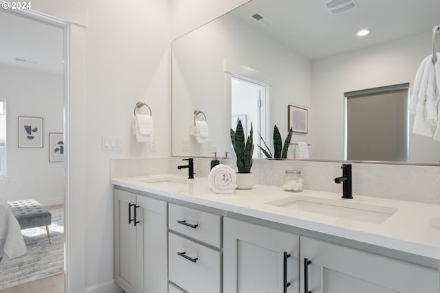 bathroom featuring vanity and backsplash