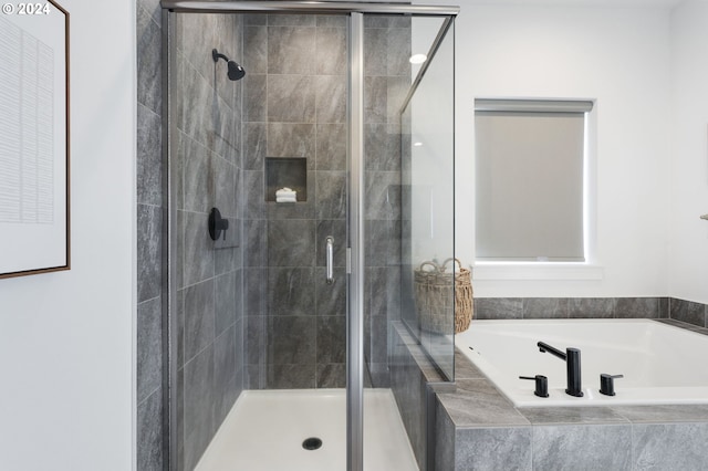 bathroom featuring shower with separate bathtub