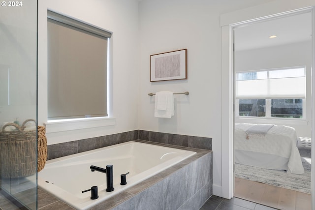 bathroom with a relaxing tiled tub