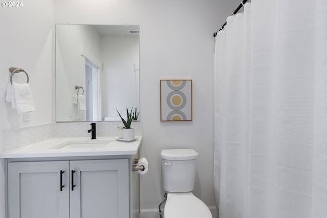 bathroom with vanity, toilet, and backsplash