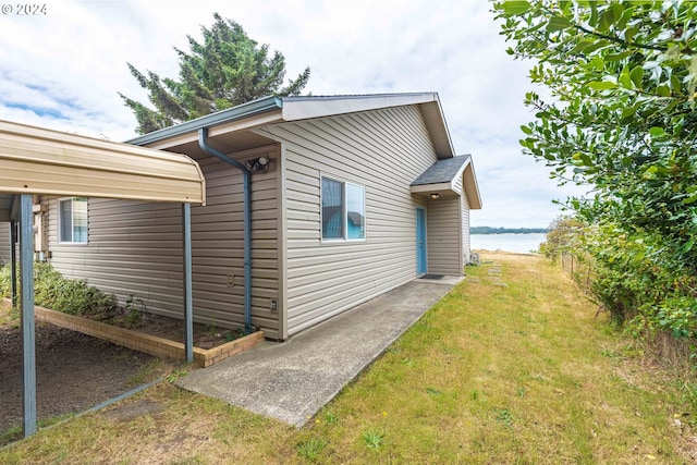 view of side of property featuring a water view and a yard