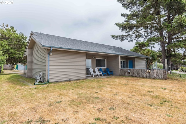 back of house with a patio area and a lawn