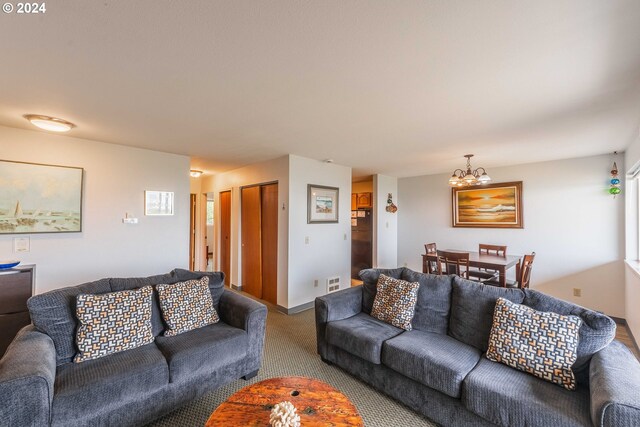 living room with an inviting chandelier and carpet