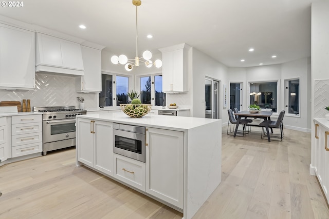 kitchen with white cabinetry, appliances with stainless steel finishes, light wood-type flooring, and tasteful backsplash