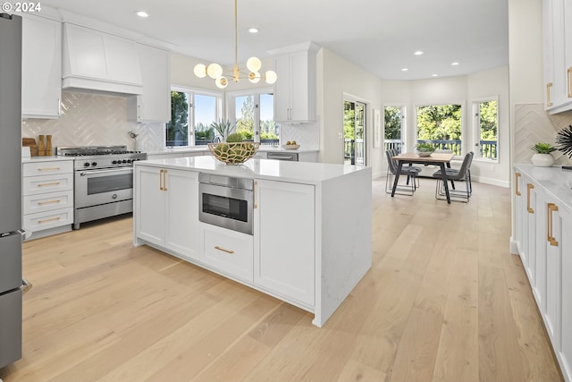 kitchen with backsplash, light hardwood / wood-style flooring, appliances with stainless steel finishes, and white cabinetry