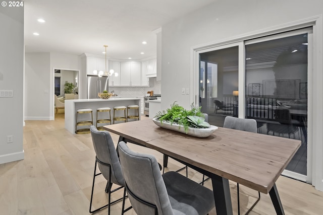 dining space featuring a chandelier and light hardwood / wood-style flooring