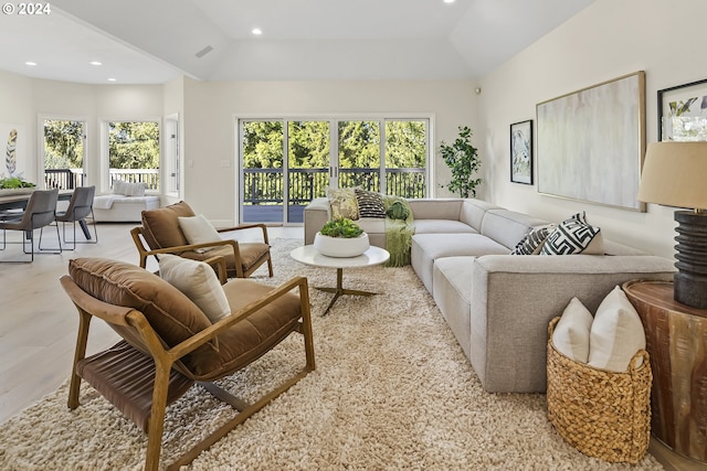 living room featuring vaulted ceiling, light hardwood / wood-style floors, and plenty of natural light