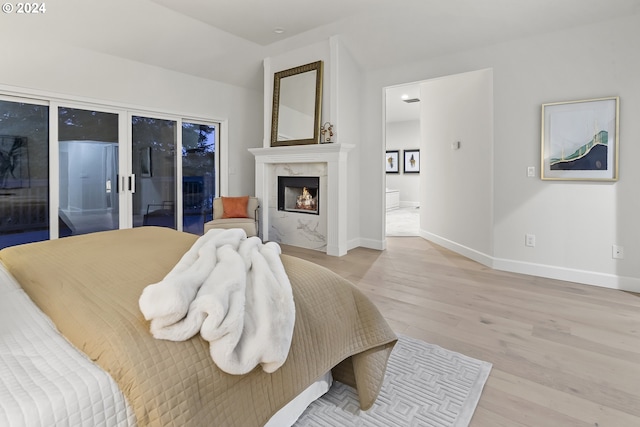 bedroom with access to outside and light wood-type flooring