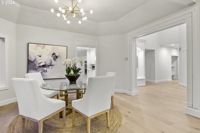 dining room with light hardwood / wood-style flooring and an inviting chandelier