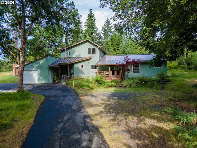 725 Snowden Rd, White Salmon, WA 98672 - view of front of house with a porch, metal roof, asphalt driveway, an attached garage, and a standing seam roof