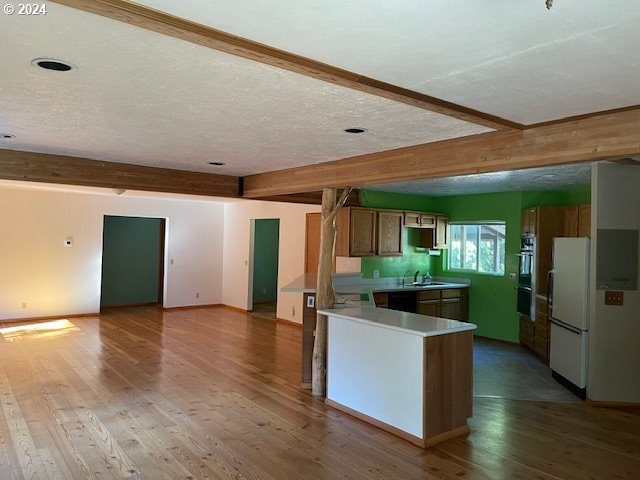 kitchen with black double oven, hardwood / wood-style floors, beamed ceiling, white fridge, and a textured ceiling