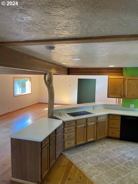 kitchen with black appliances, kitchen peninsula, a textured ceiling, and light hardwood / wood-style flooring