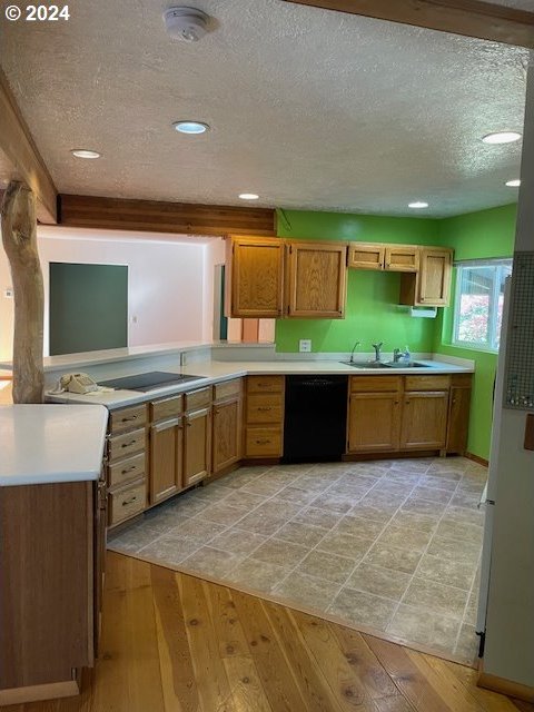 725 Snowden Rd, White Salmon, WA 98672 - kitchen with black dishwasher, a sink, a textured ceiling, light wood-type flooring, and brown cabinetry