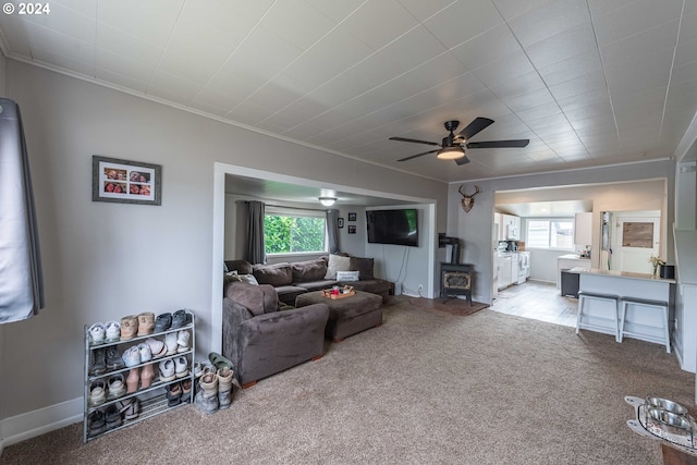 carpeted living room with crown molding and ceiling fan