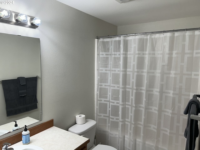 bathroom with a shower with curtain, toilet, and vanity