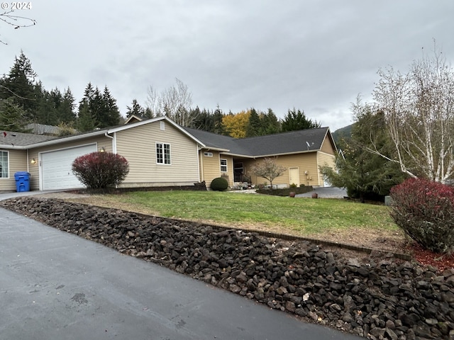 ranch-style home with a garage and a front lawn